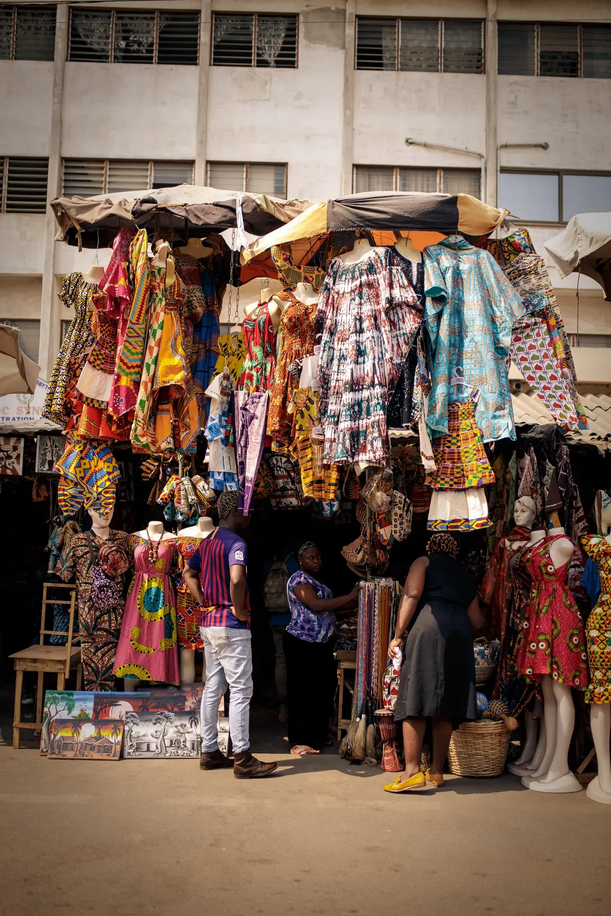 Racks of printed African fabrics at a market stall.