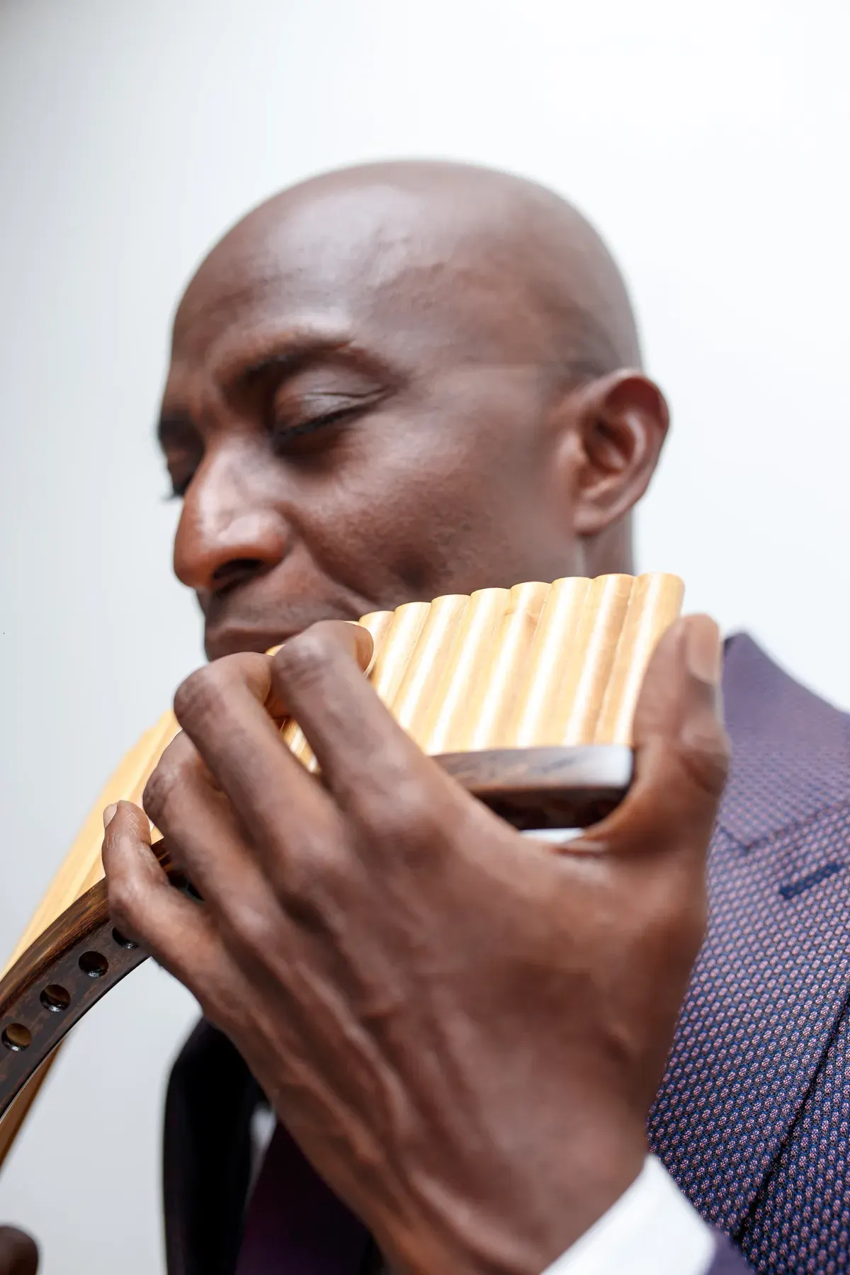 Close-up of Richard Meseko’s hands and the reeds of the pan flute as he plays.
